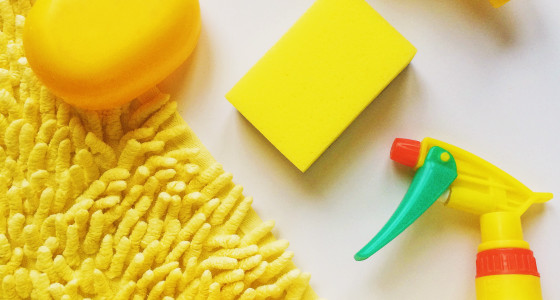 Yellow mat with yellow soap, spray and sponge on top