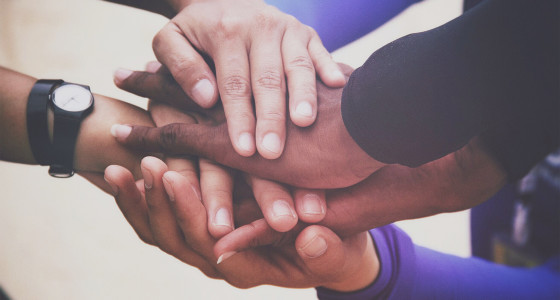 Group of people of mixed ethnicities touching hands