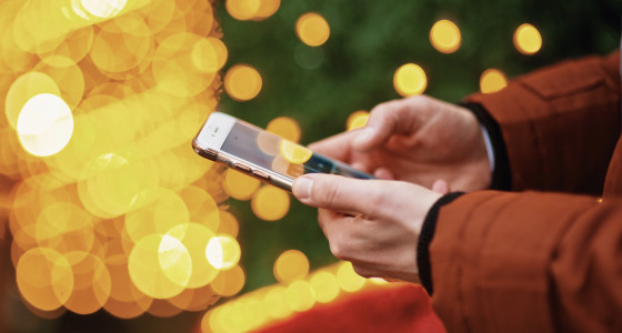 Hands holding phone with glowing background.