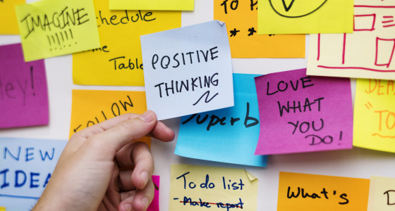 hand placing sticky note on wall.