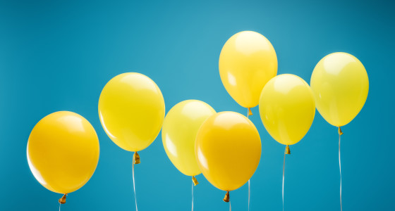 bright party yellow balloons on blue background