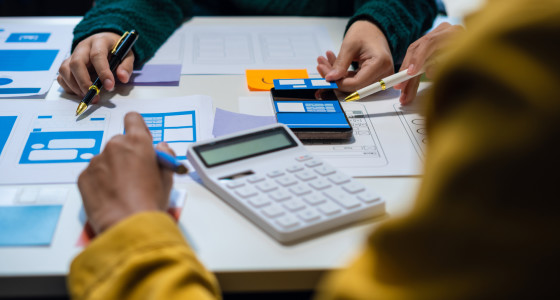 Two people, paperwork and a calculator