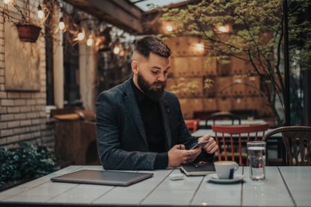 Businessman in cafe looking at smartphone.