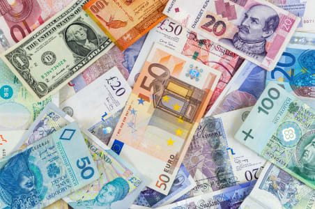 Different banknotes scattered as background.