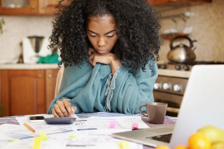 woman looking at paper bills