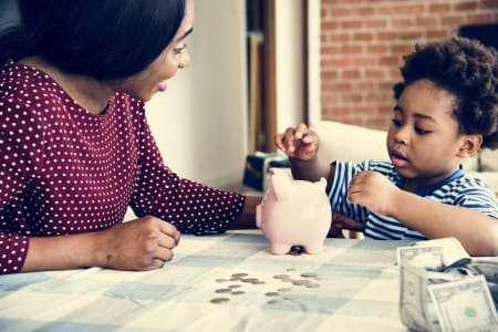 Women and son using piggy bank to save