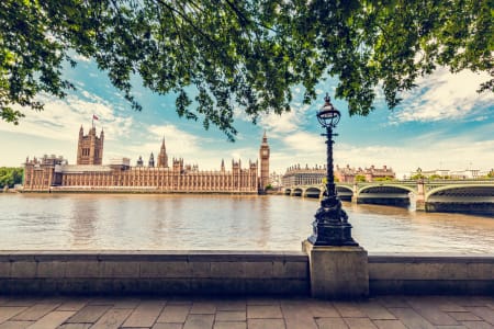 a sunny view of Parliament from across the River Thames.