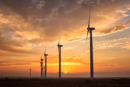 Offshore wind farm with a sunset background.