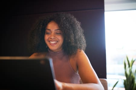 Young woman sitting at a table planning on her laptop