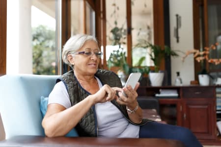 Smiling older woman using a mobile phone