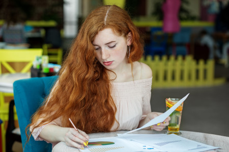 Young women sits at table learning about finance.