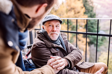 Older man with young son outside.