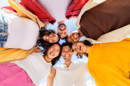 A group of friends smiling down on a sunny day.