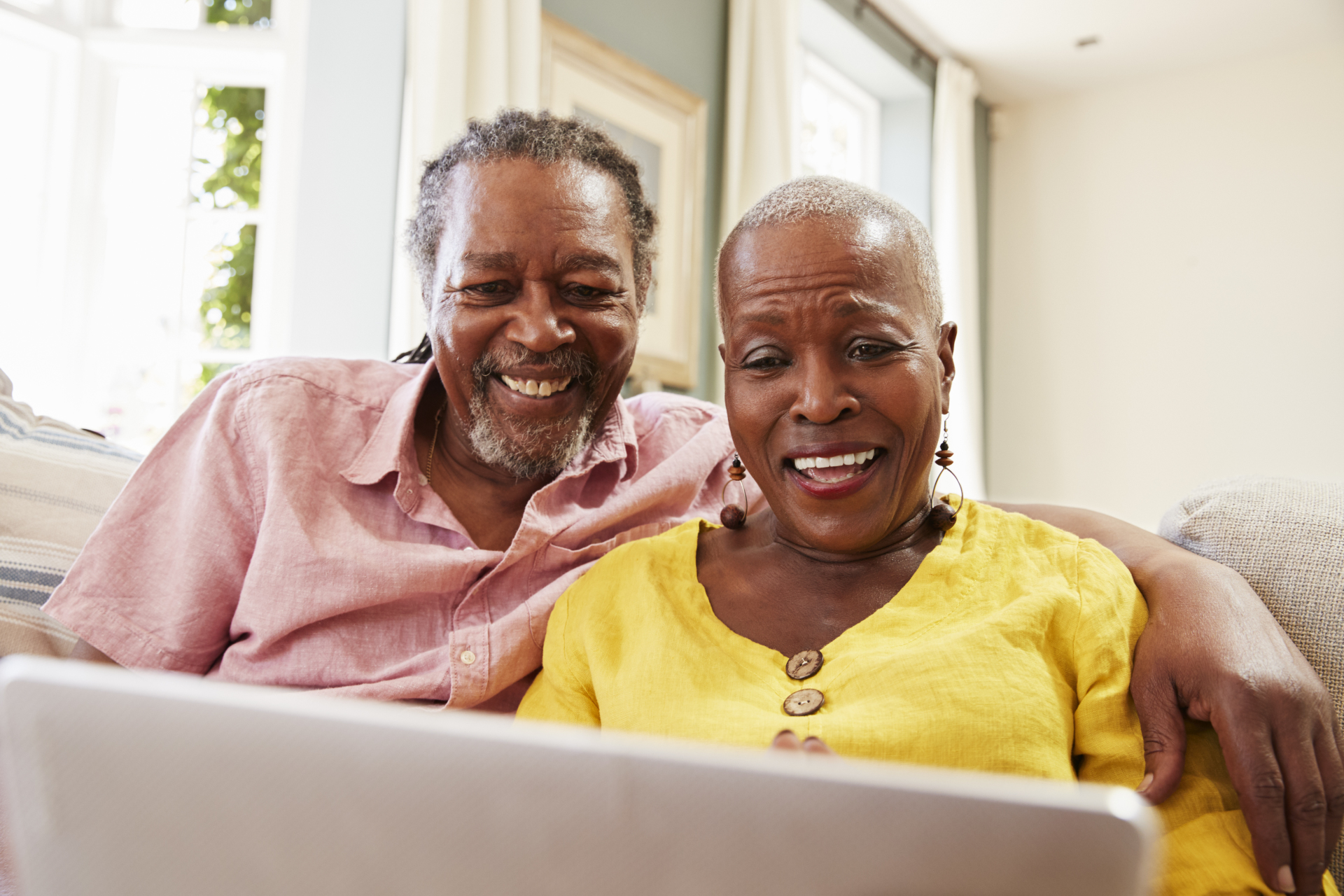 Happy couple looking at laptop.