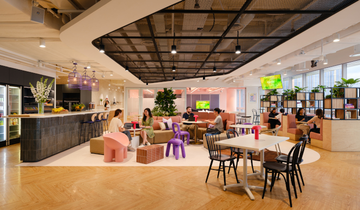 The collaboration area in Wise's Singapore office, with people sitting at well spaced and well lit tables.