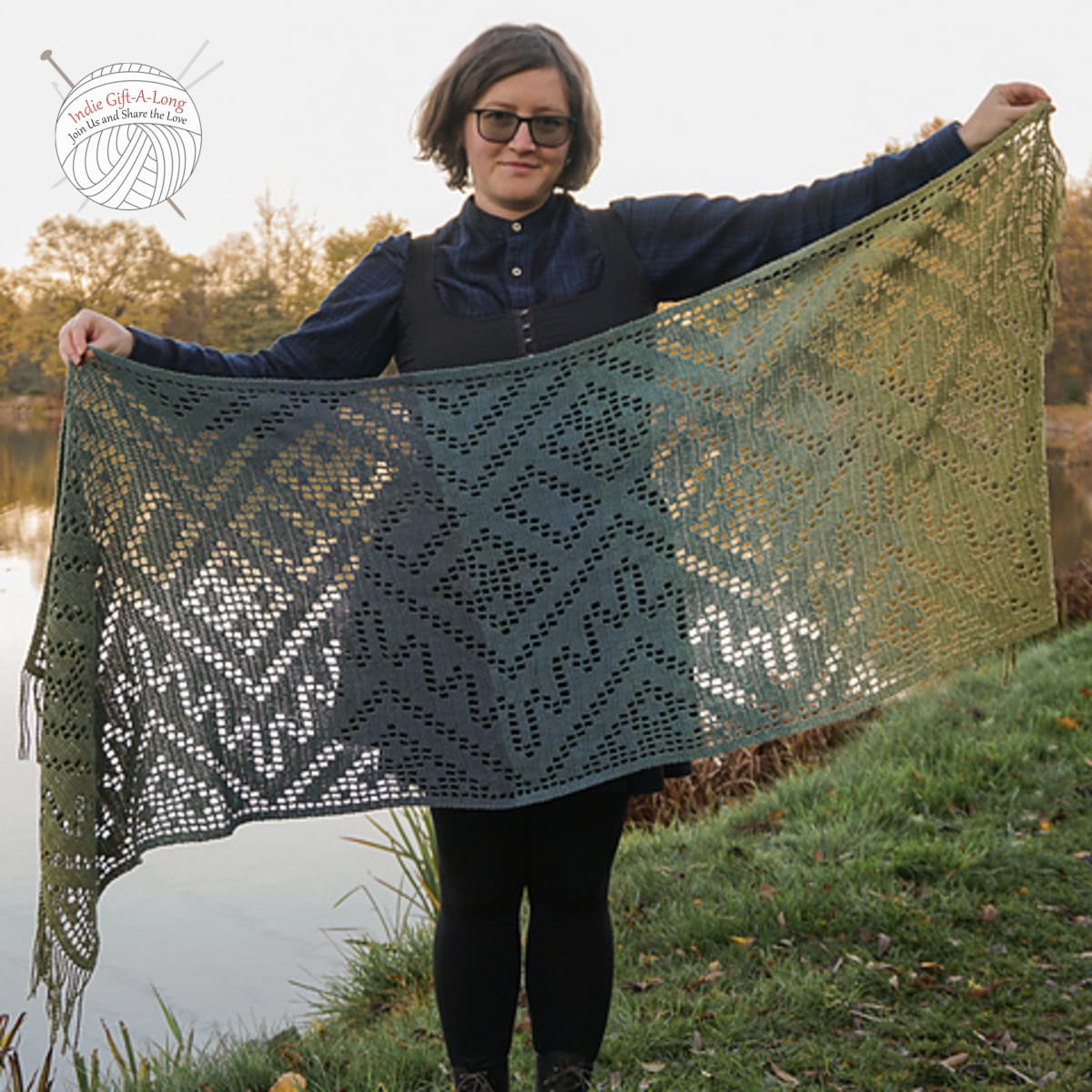 Woman holding crocheted shawl with geometric lace motifs.