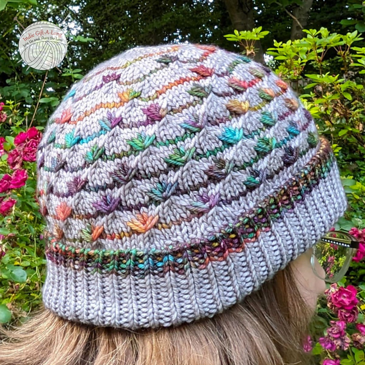 Woman wearing grey hat with rainbow texture details.