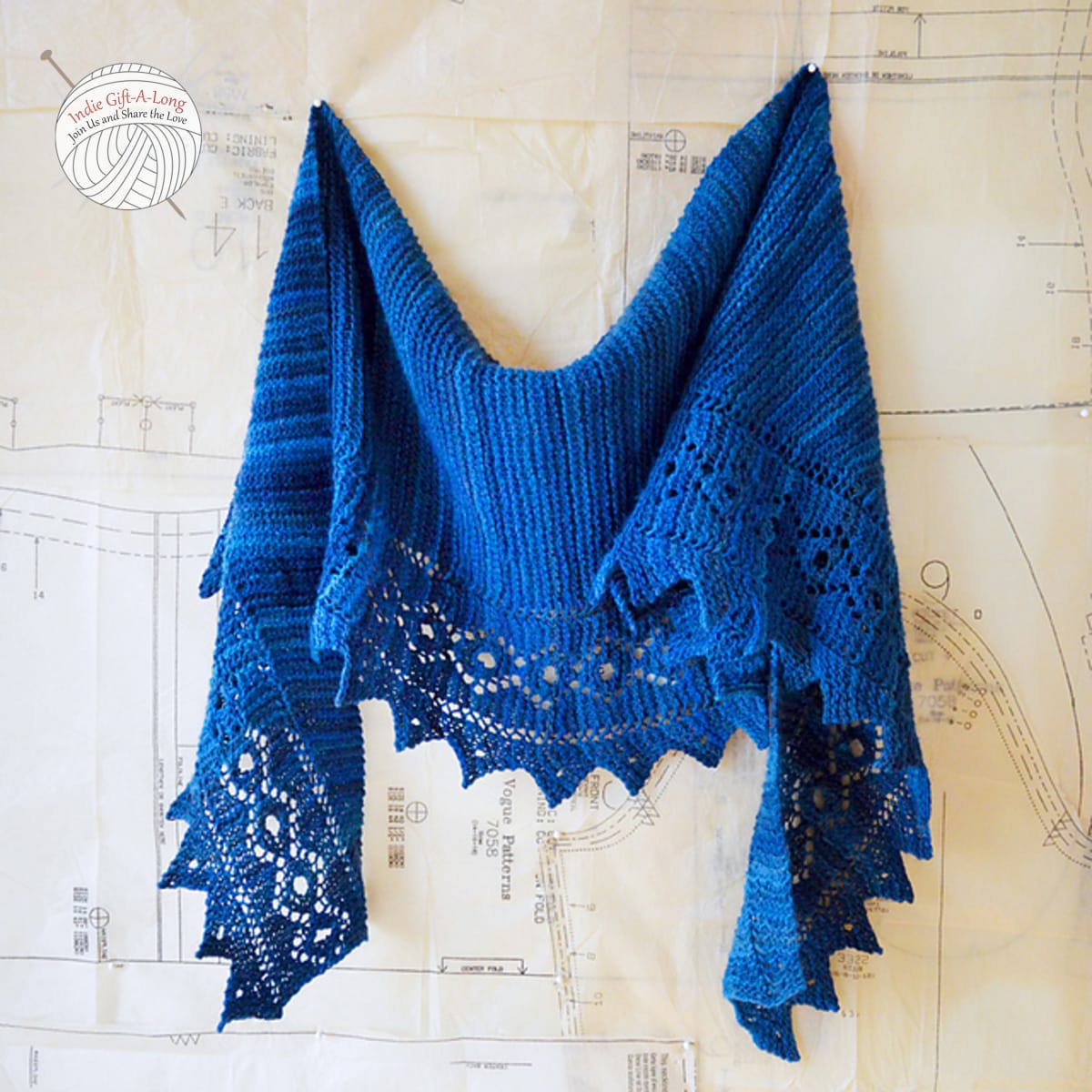 Blue knitted shawl with lace edge.