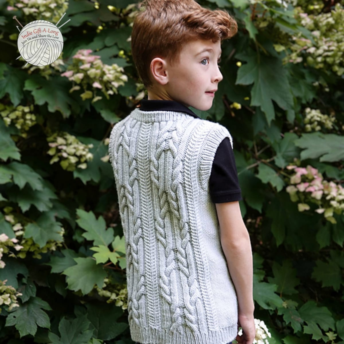 Boy wearing light grey knitted vest with cable patterning.