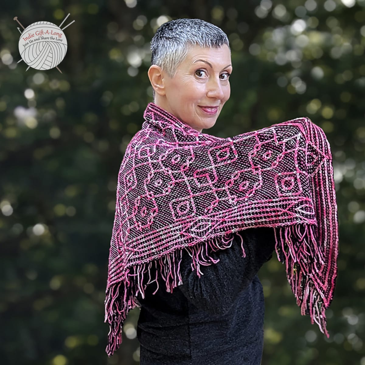 Woman wearing knitted shawl with intricate pink cables.