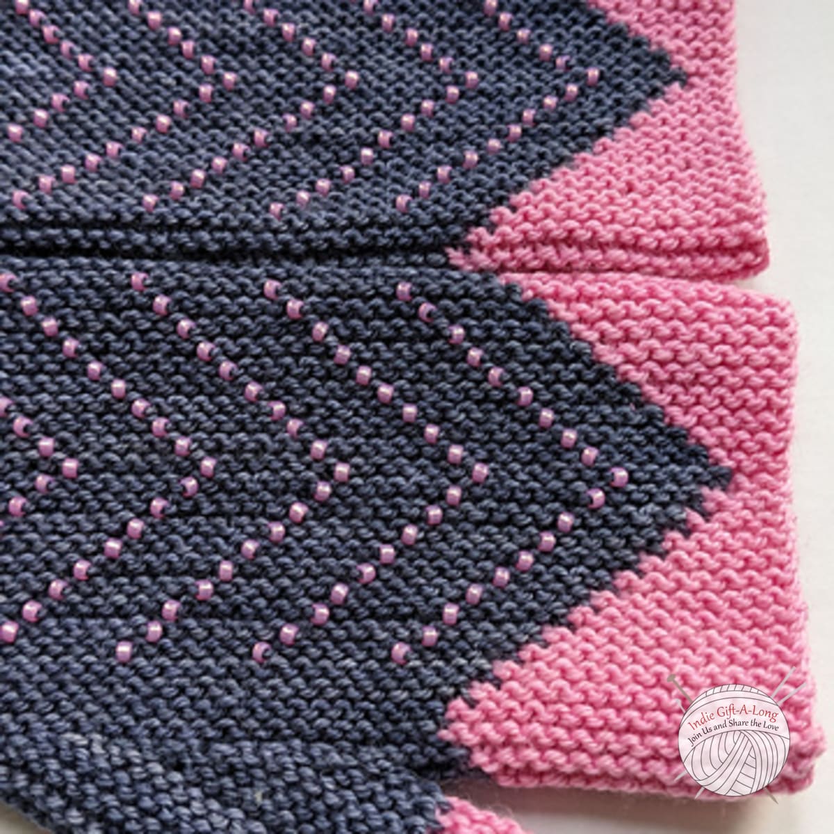 Knitted pink and grey fingerless mitts with chevron beaded pattern.