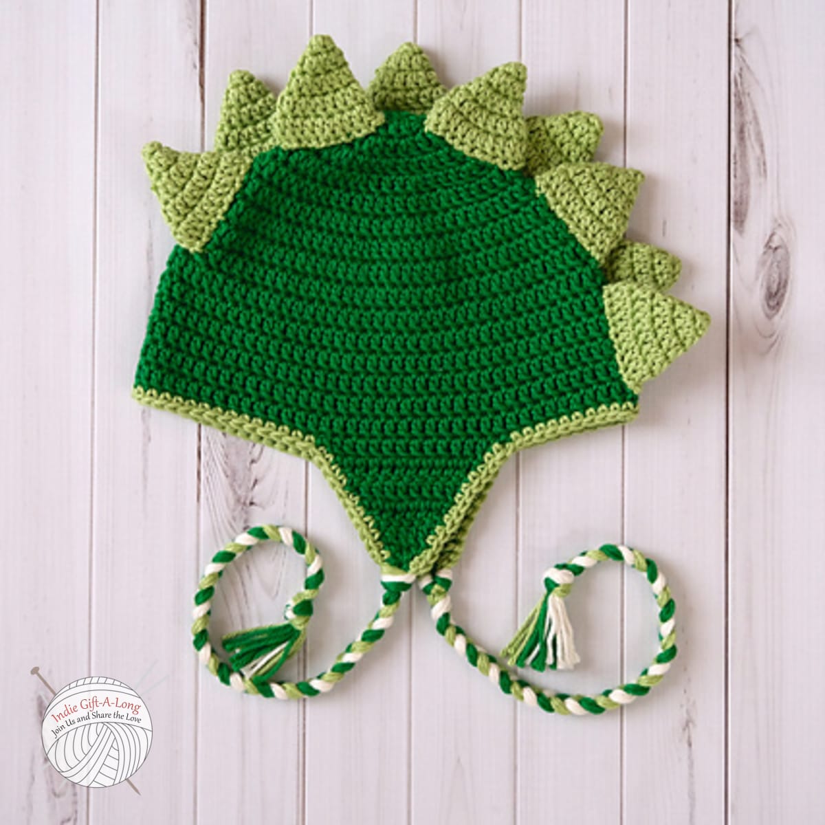 Green crocheted hat with dinosaur plates.