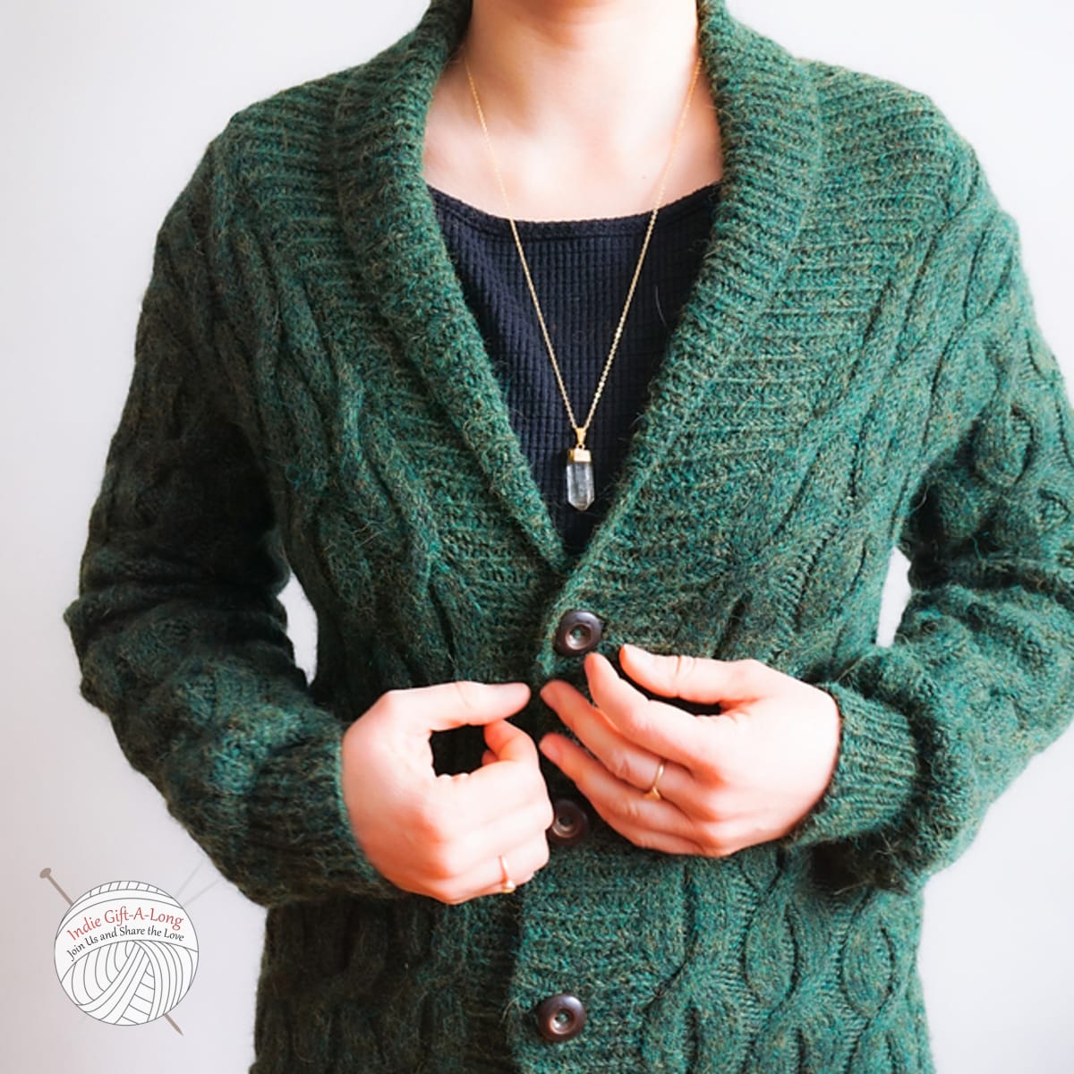 Woman wearing green knitted cardigan with cables.