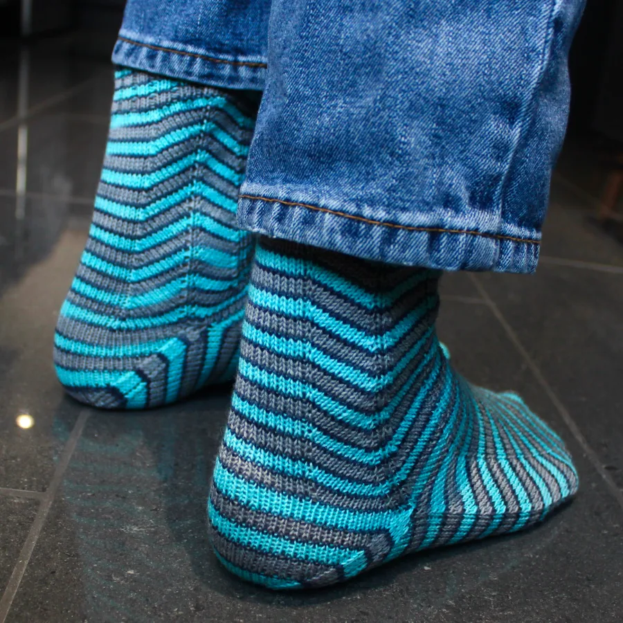 Right-side view of grey and blue socks with stripes that are distorted on the sides.