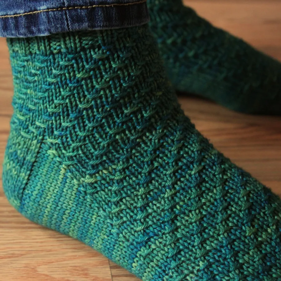 Close up of feet wearing rich green socks with spiral texture.