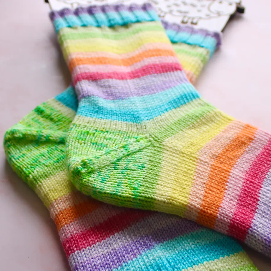 Close view of rainbow striped socks on sock blockers with green speckled heel.