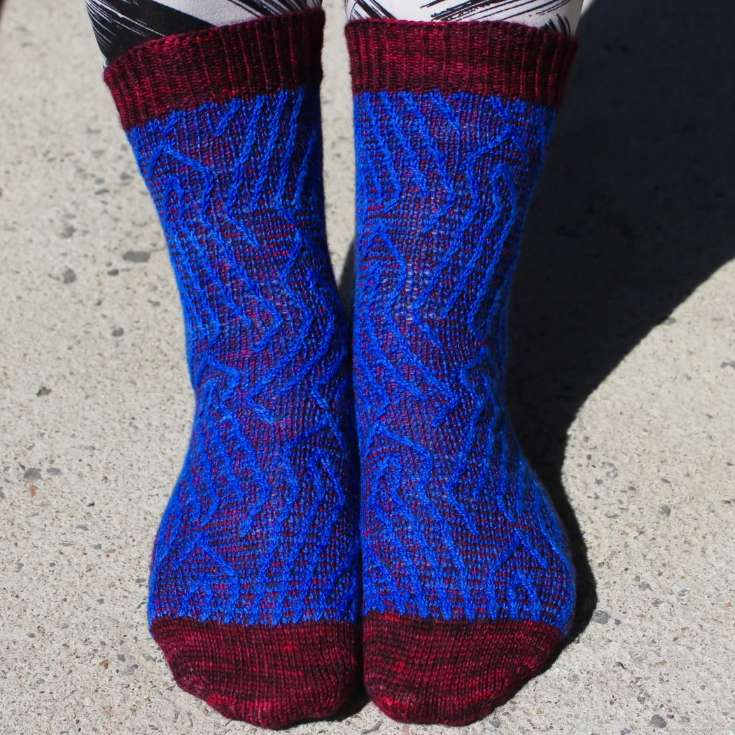 Front view of red and blue socks with vertical stripes that create an abstract surface texture.