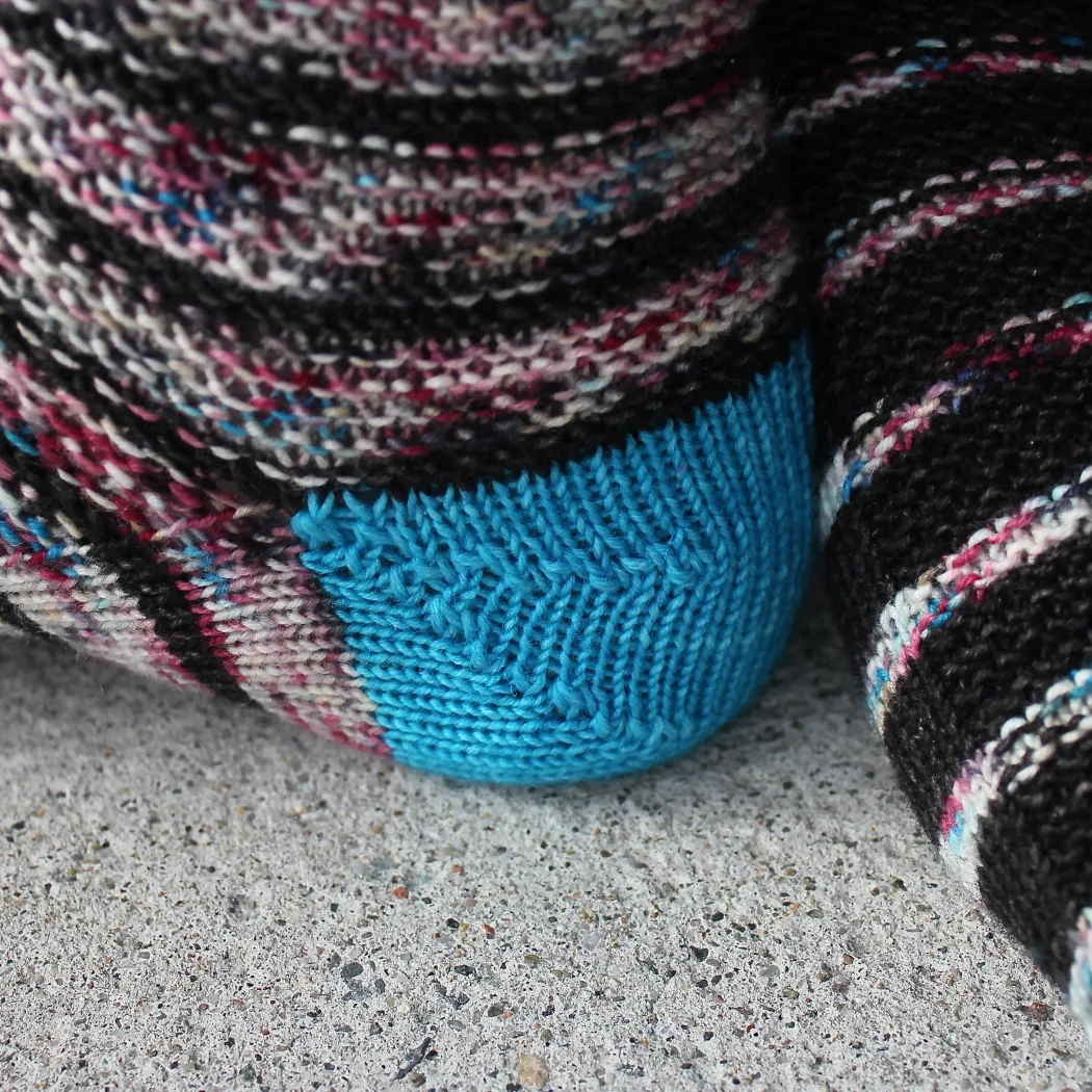 Close-up side view of bright blue rounded three-wedge sock heel.