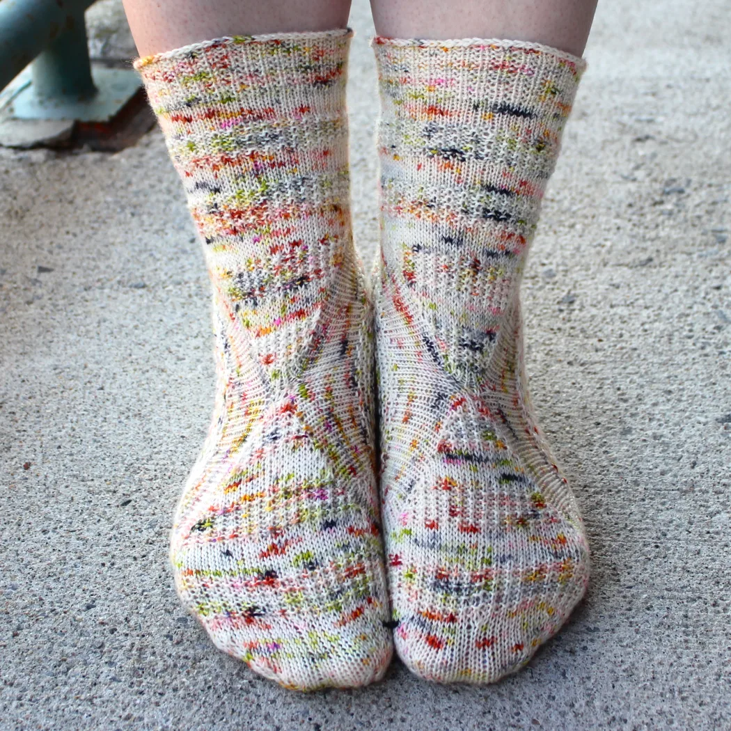 Front view of heavily-speckled white socks with semicircular texture details.