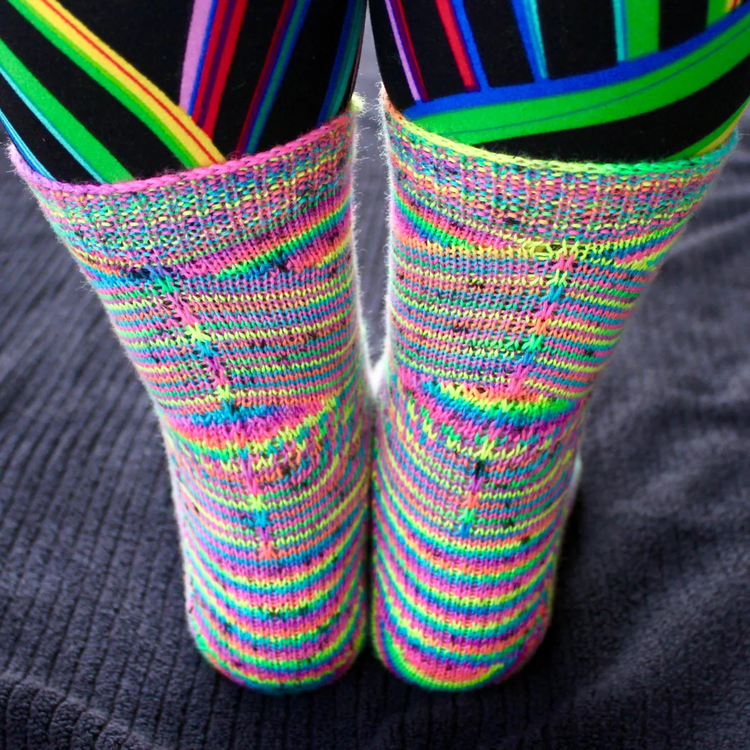 Back view of rainbow socks with shifting and pooling colour patterns and surface texture.