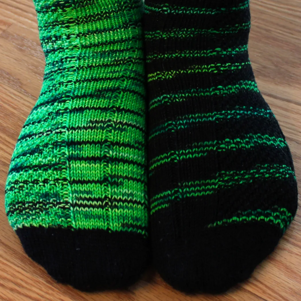 Close up of feet wearing green and black socks with texture detail.