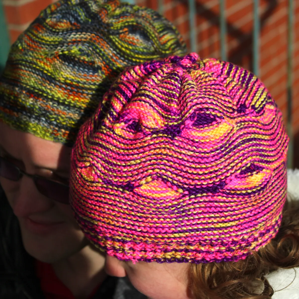 Child and man wearing hats with large wavy textured pattern.