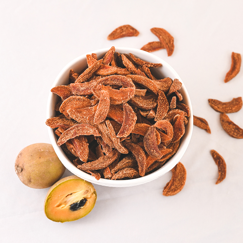 Stacks of sweet dried chikoo chips with rich caramel color on a light beige background with dramatic minimalist shadows - Thumbnail 3