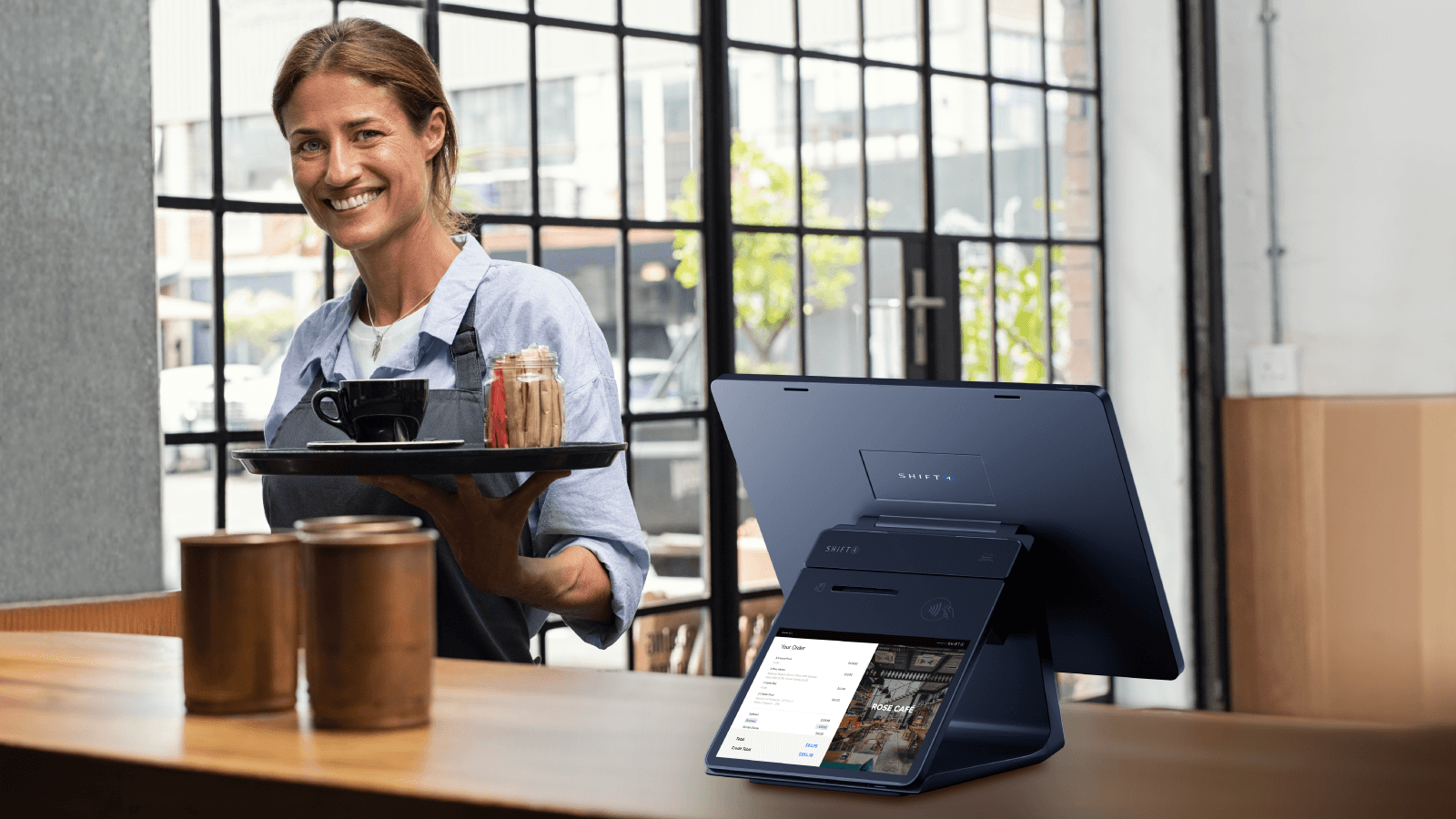 Customer-facing display on a checkout counter in a restaurant. A waitress is holding a tray of food and smiling. CFD. SkyTab