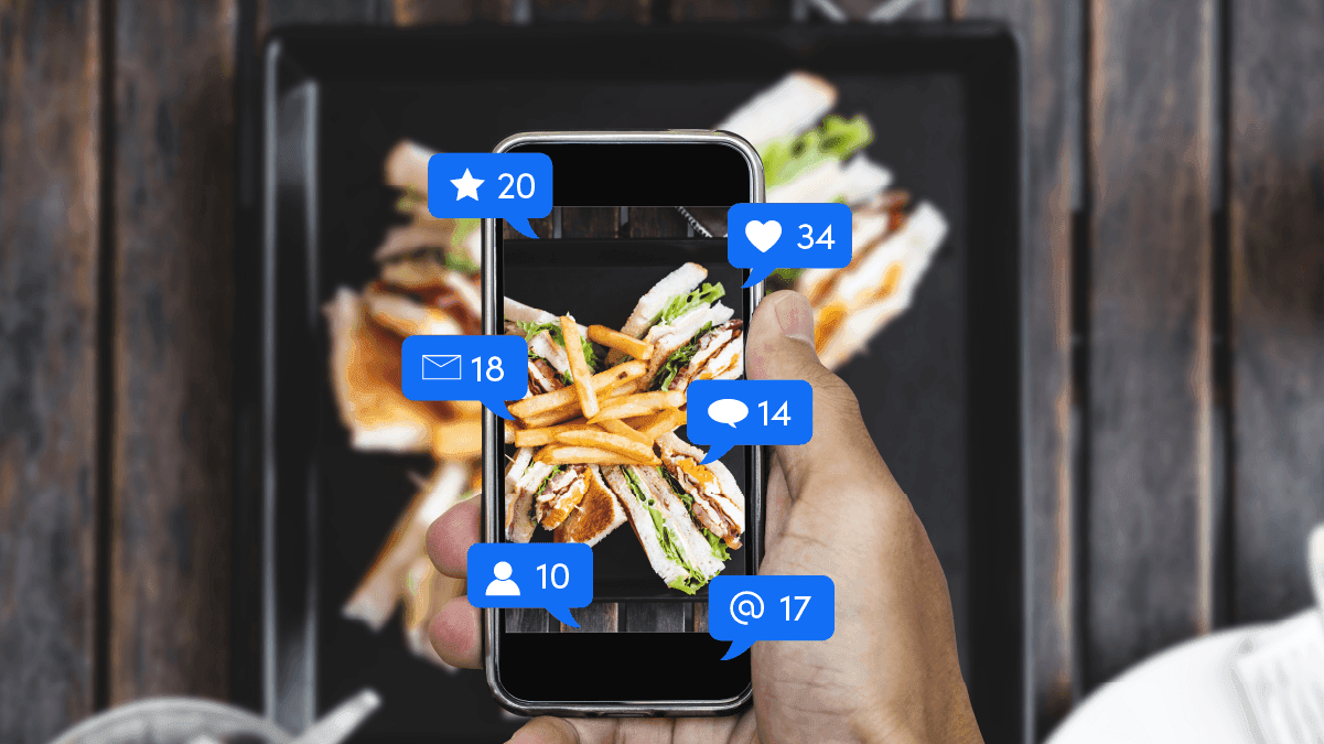 Person posting a picture of food on social media with notifications surrounding the phone - SkyTab - Shift4