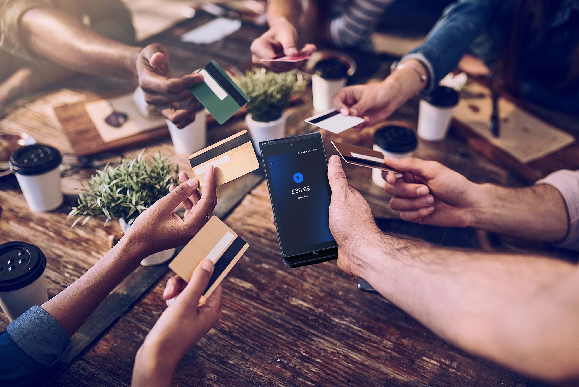 Customers at a restaurant table using their cards for tap to pay on a SkyTab Mobile POS device