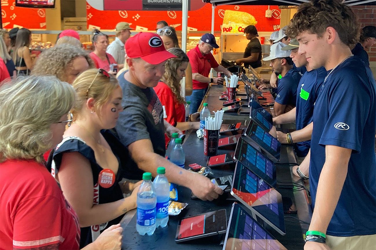 Sports fans paying at concessions with employees using SkyTab Venue POS systems
