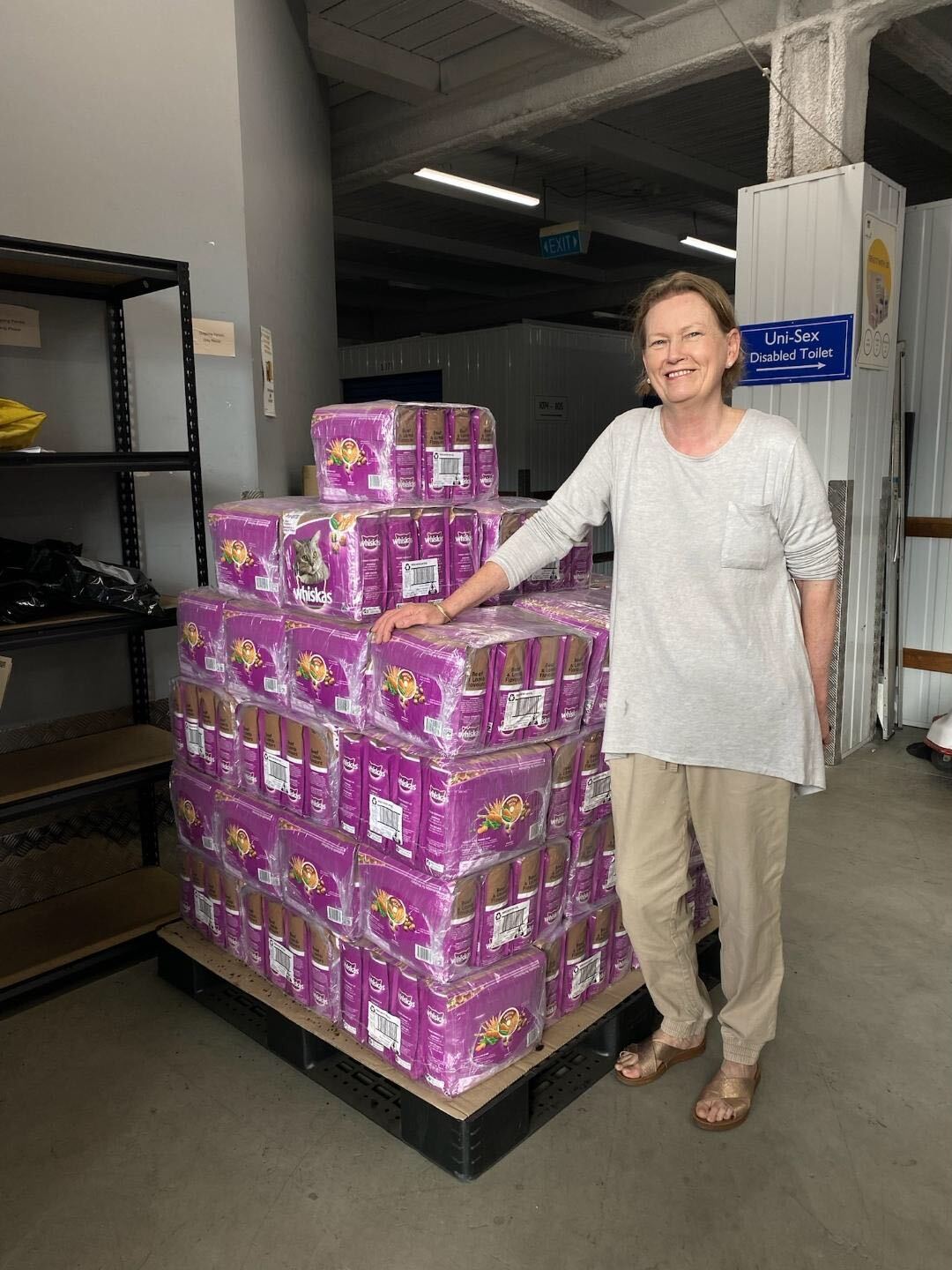 A person with a big stack of Whiskas food