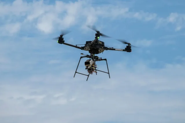 A remotely piloted drone with four rotors carries a guidance and navigation experiment through flight maneuvers.