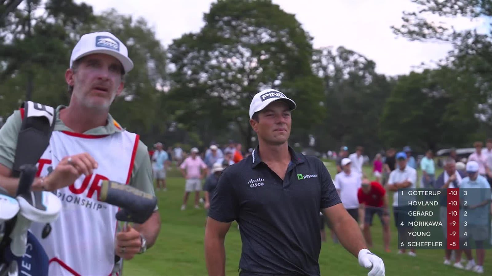 Viktor Hovland standing on the tee box examining his club during tournament play