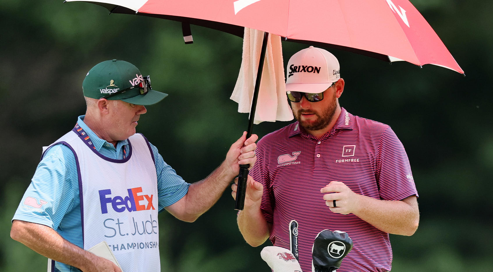 Matthew NeSmith takes shelter from the sun under an umbrella Friday. (Andy Lyons/Getty Images)