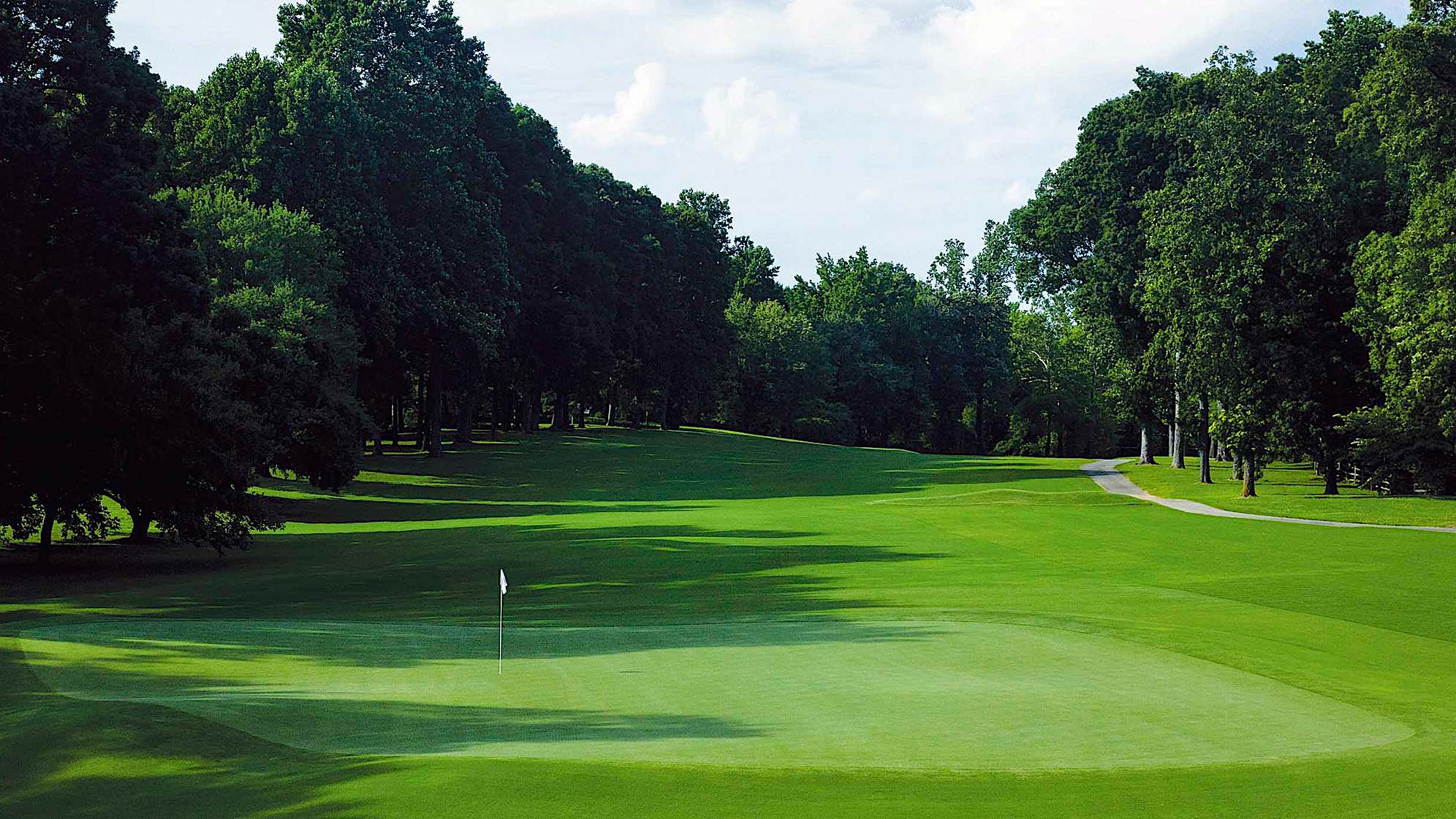 Additional length will require a semi blind tee shot to a left to right sloping fairway. The ideal drive is hard up the left side near the bunker. This low profile green is accessible with an aerial or low running ground stroke.