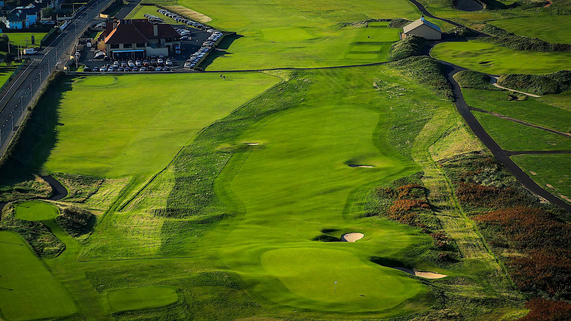 HUGHIES: A very strong opening hole with two bunkers that need to be avoided from the tee. The priority is to get the ball in play off the tee and take on the second shot to an elevated two-tier green with a false front. The reason the hole is such a good one lies almost entirely with the character of the green which Harry Colt designed. The shapes are wonderful, dividing the surface into quadrants for flag positions. The front two spots are the most testing as any shot which is under-hit will fall back off the front and run down the approach or into the cavernous bunkers. (Descriptions courtesy of the R&A)