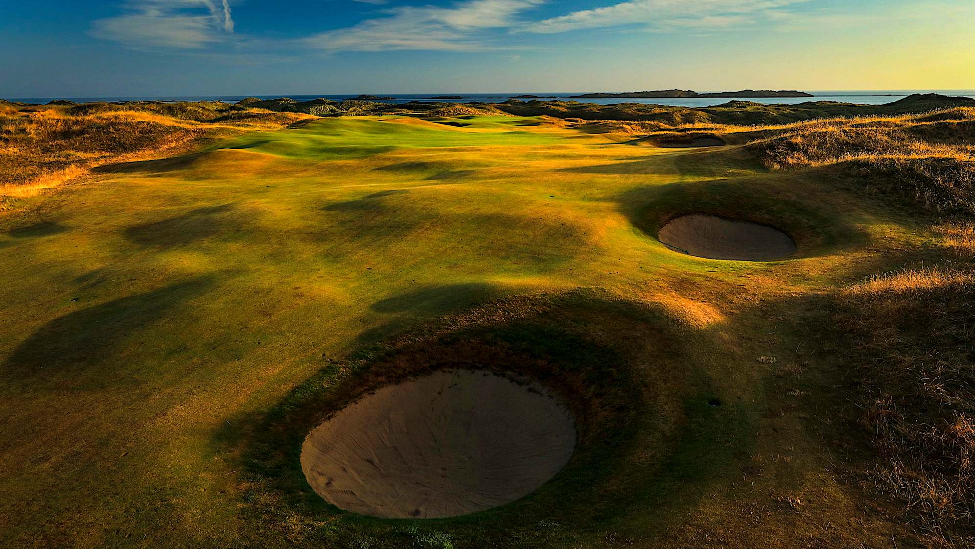 SKERRIES: The 15th hole requires an uphill tee shot to a generous fairway that slopes against the route of the hole. A new fairway bunker to the right of the fairway will make players think twice about driver, but laying up too far back will leave the green out of sight for the approach shot. The view of the approach is arguably the most photogenic on the course. The second shot is key as the green is small and guarded by bunkers left and a severe slope front and right. (Descriptions courtesy of the R&A)