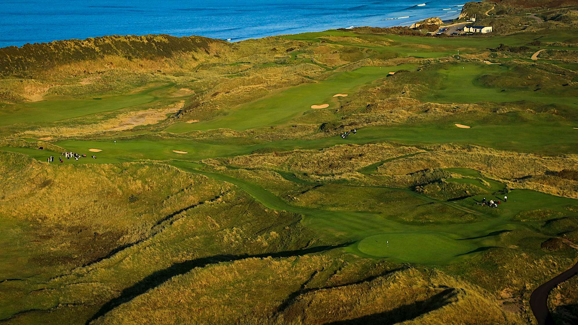 CALAMITY CORNER: No. 16 is aptly named ‘Calamity.’ No bunkers are required here – the name says it all. The tee-shot is played slightly uphill over an expansive ravine of rough. Any shot falling short and right is likely to make for a very difficult up-and-down, potentially from 50 feet below the green. In 1951, Bobby Locke took one look at the hole and decided to play to the left during all four rounds. He played into a hollow, now named after him, and got up-and-down in all four rounds to save par. (Descriptions courtesy of the R&A)