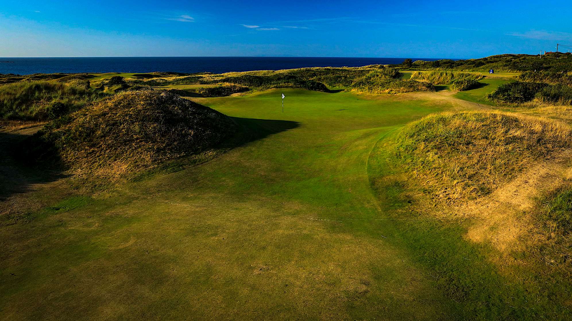 FRED'S DALY: The fourth hole is one of the best holes on the course and named after Portrush local Fred Daly, winner of The Open in 1947. The out of bounds runs menacingly all the way down the right of the hole so the tee-shot needs to be threaded between the left fairway bunkers and the out of bounds. The green is surrounded by sand-hills, which makes it difficult to hit and the flag is often partially hidden from sight. (Descriptions courtesy of the R&A)